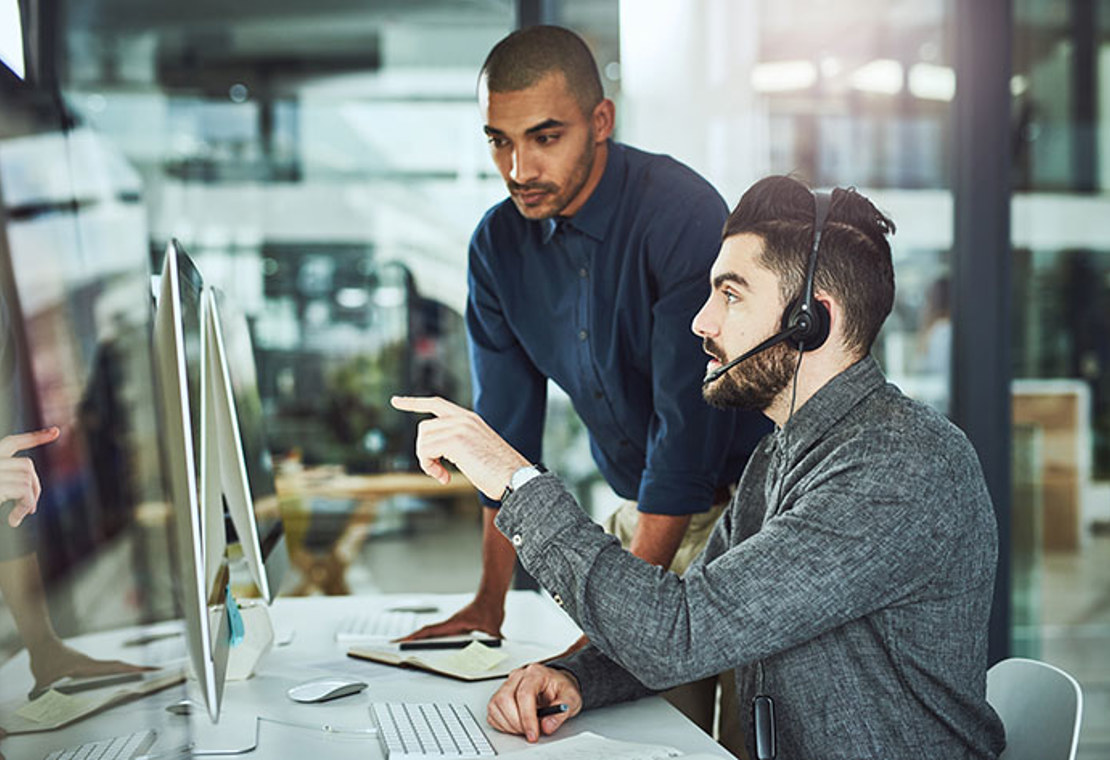 Man pointing at computer and man checking