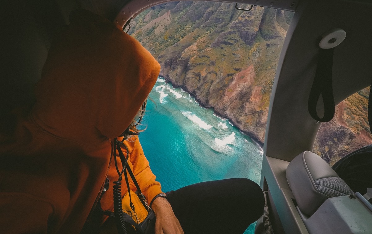 Person i helikopter ser ut på naturen.